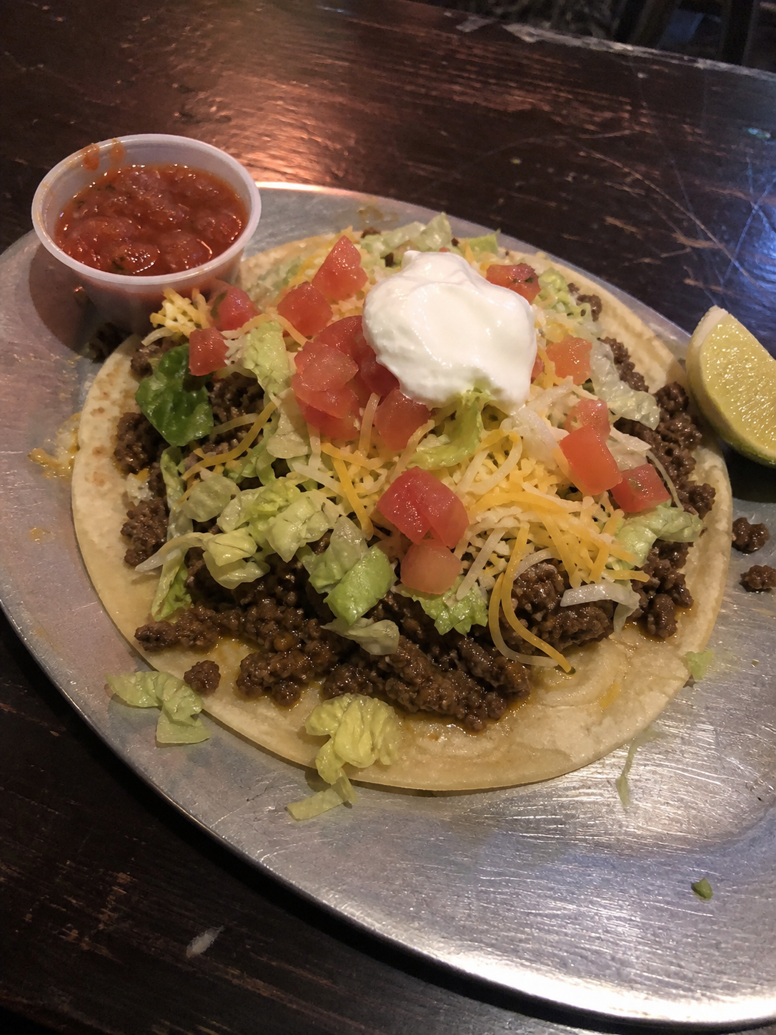 Beef taco with lettuce, tomato, cheese and sour cream