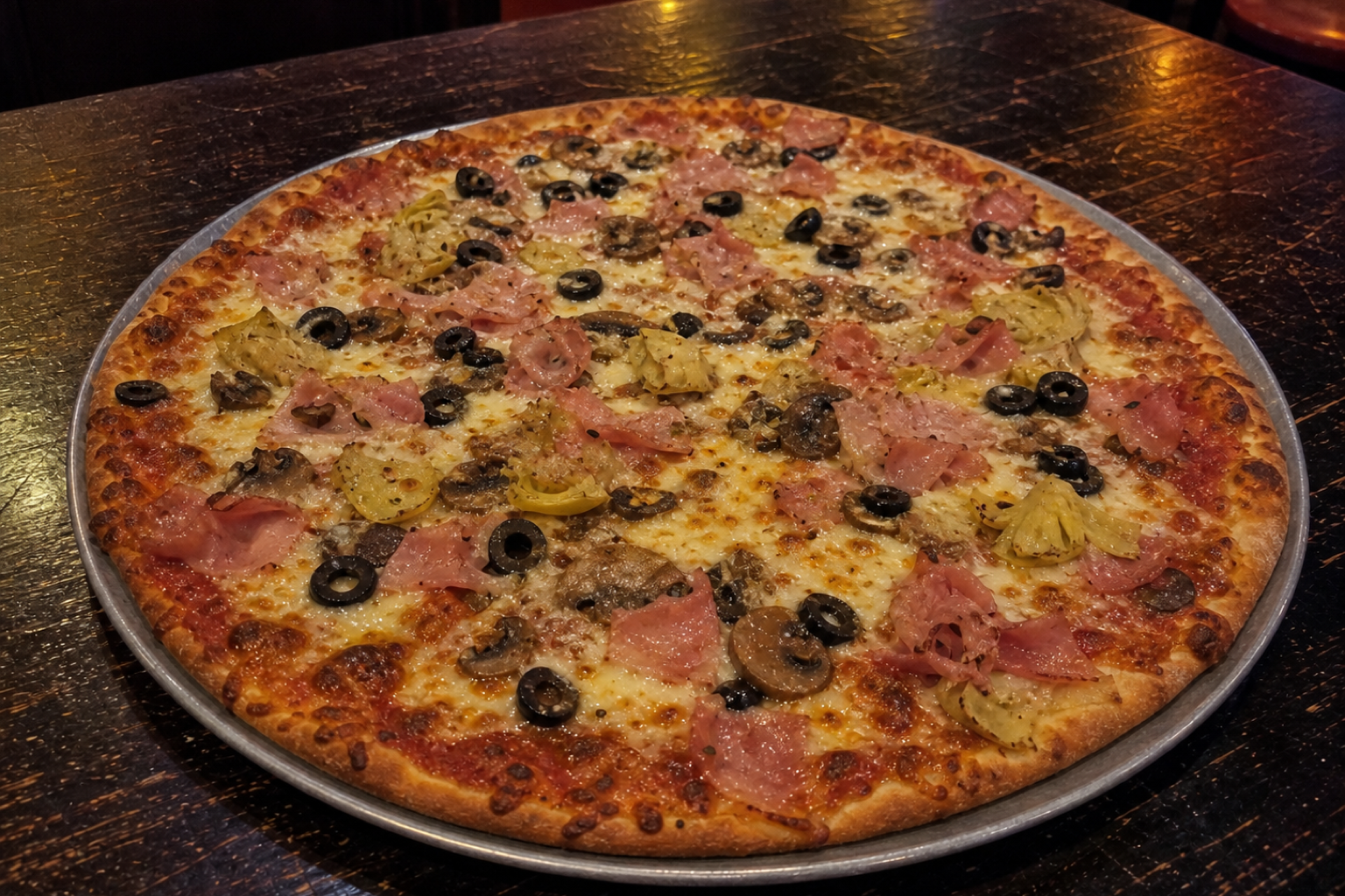 Hand-tossed Capricciosa pizza with ham, mushrooms, olives and artichokes