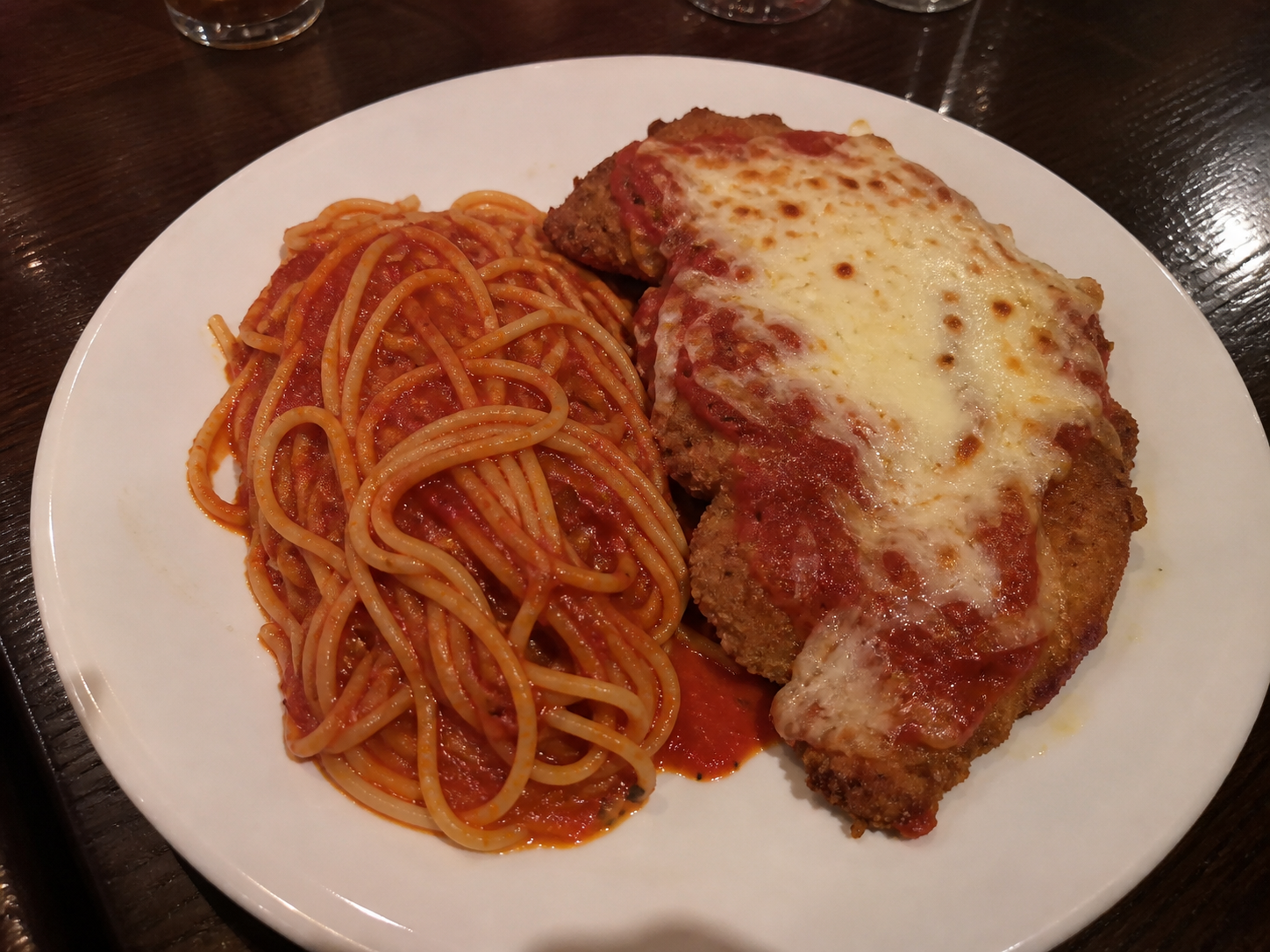 Chicken parmigiana served with spaghetti and tomato sauce