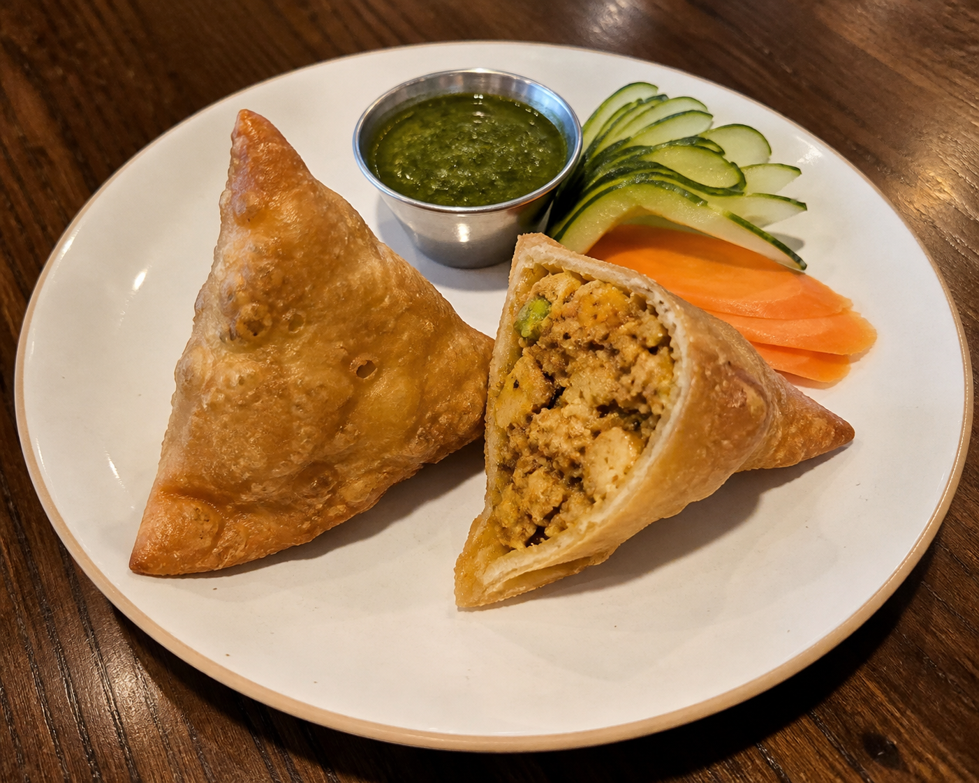 Two chicken samosas with green chutney