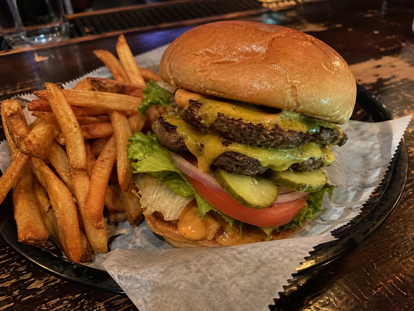 Double deluxe burger with cheese, lettuce, tomato, pickles, onion and fries