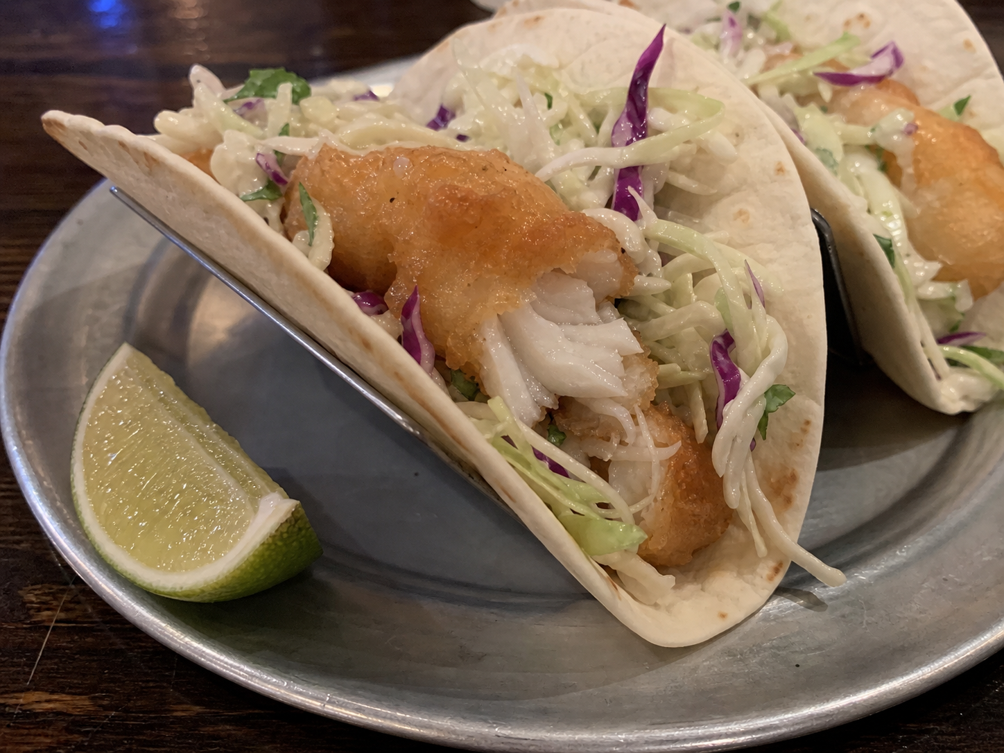 Fish taco with crispy fish, cabbage and lime