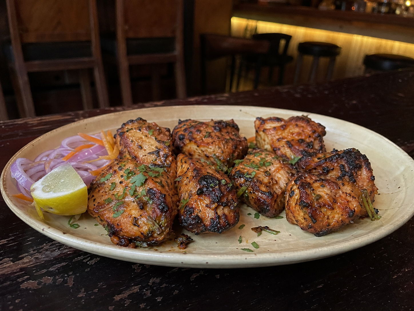Garlic fish tikka with charred edges, onion and lemon