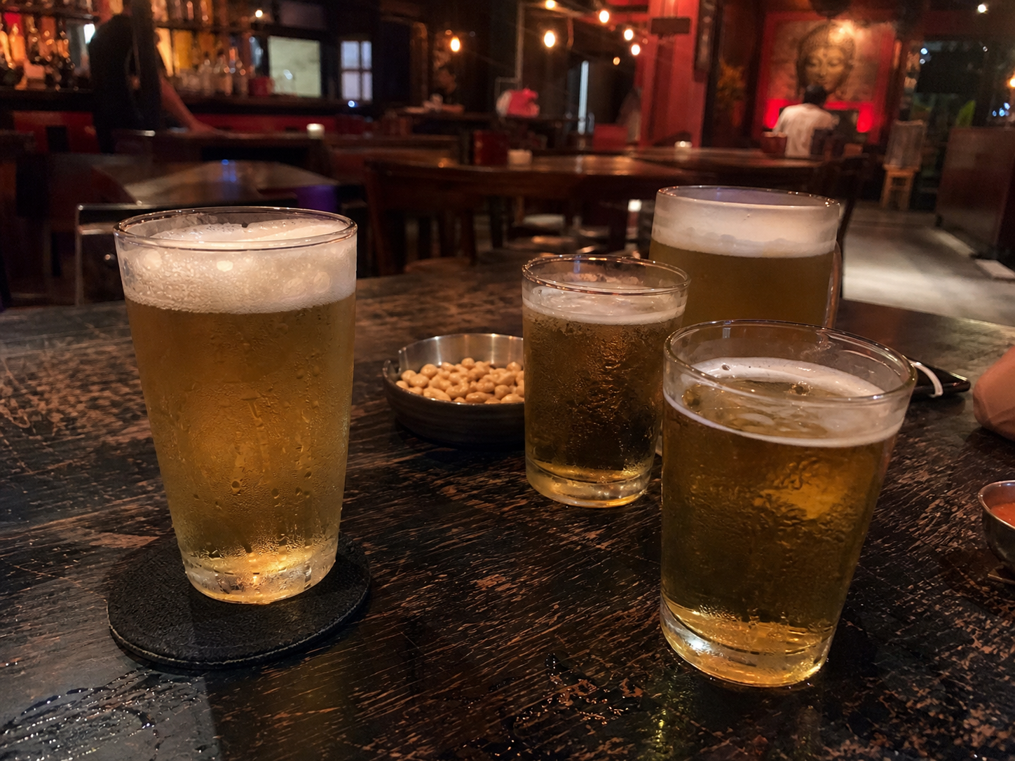 Cold draught beers on a worn bar table during free-flow beer promotion