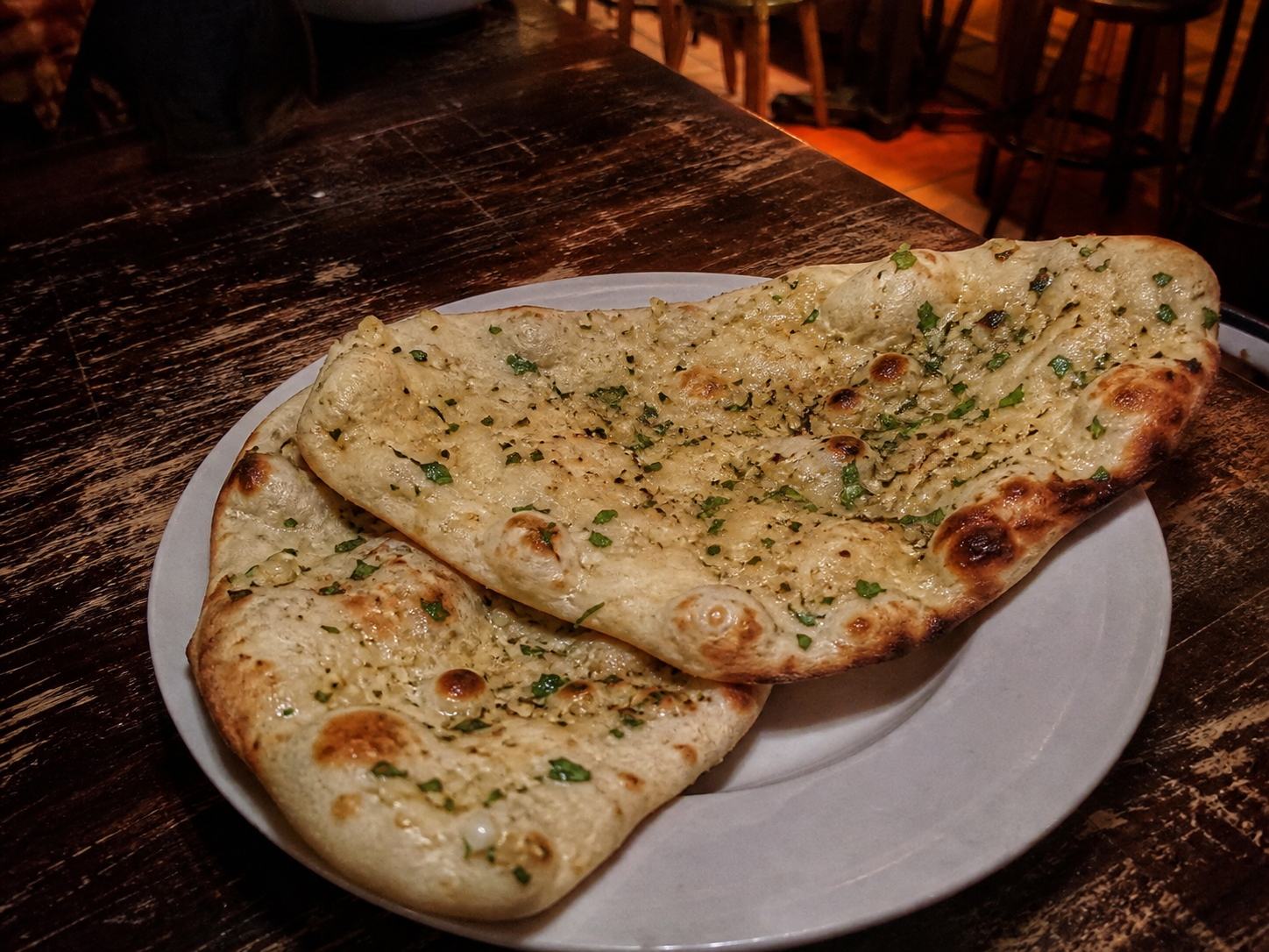 Garlic naan topped with chopped garlic and coriander
