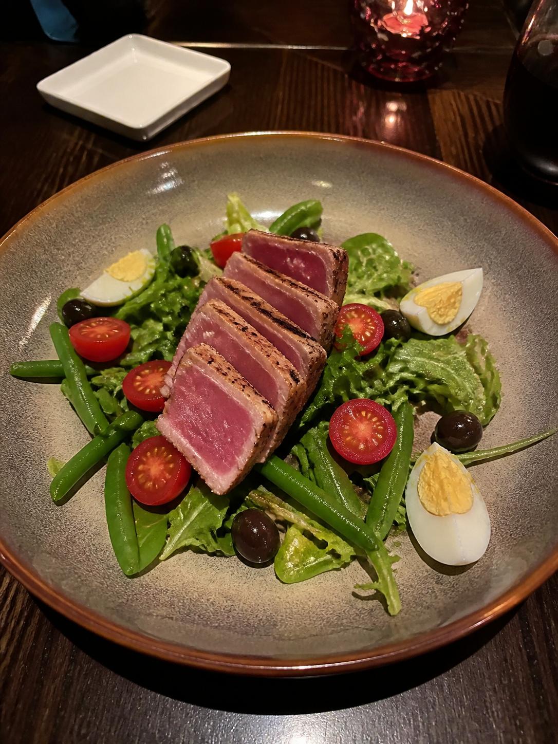 Nicoise tuna salad with greens, tomato, green beans, olives and boiled egg