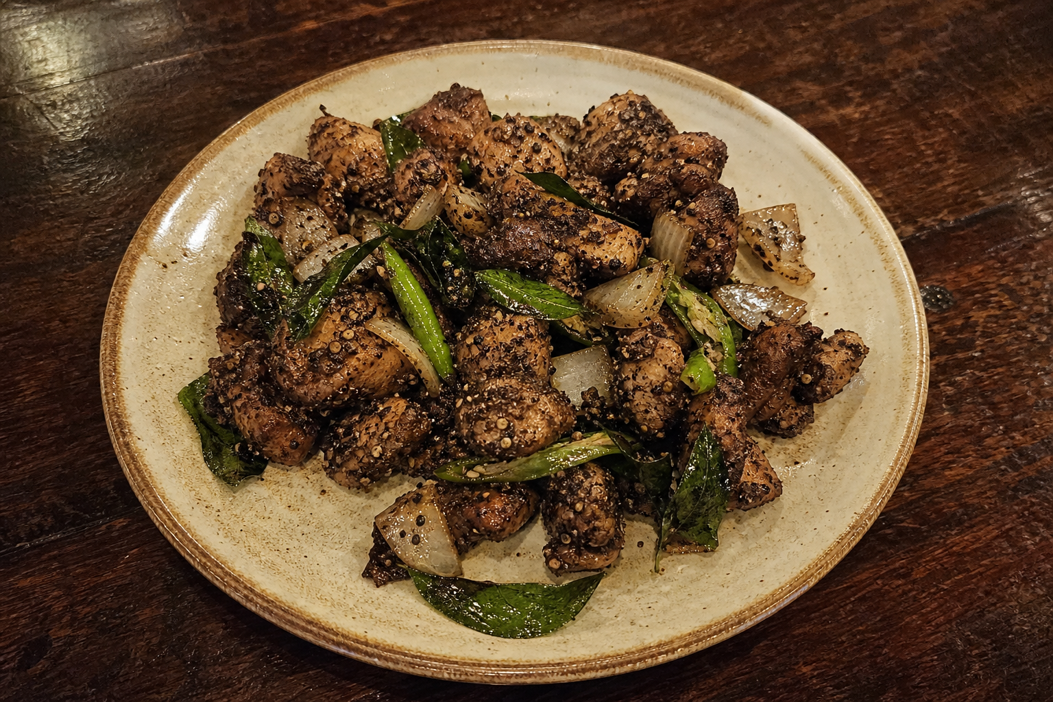 Dry pepper chicken with cracked black pepper, curry leaves and onion