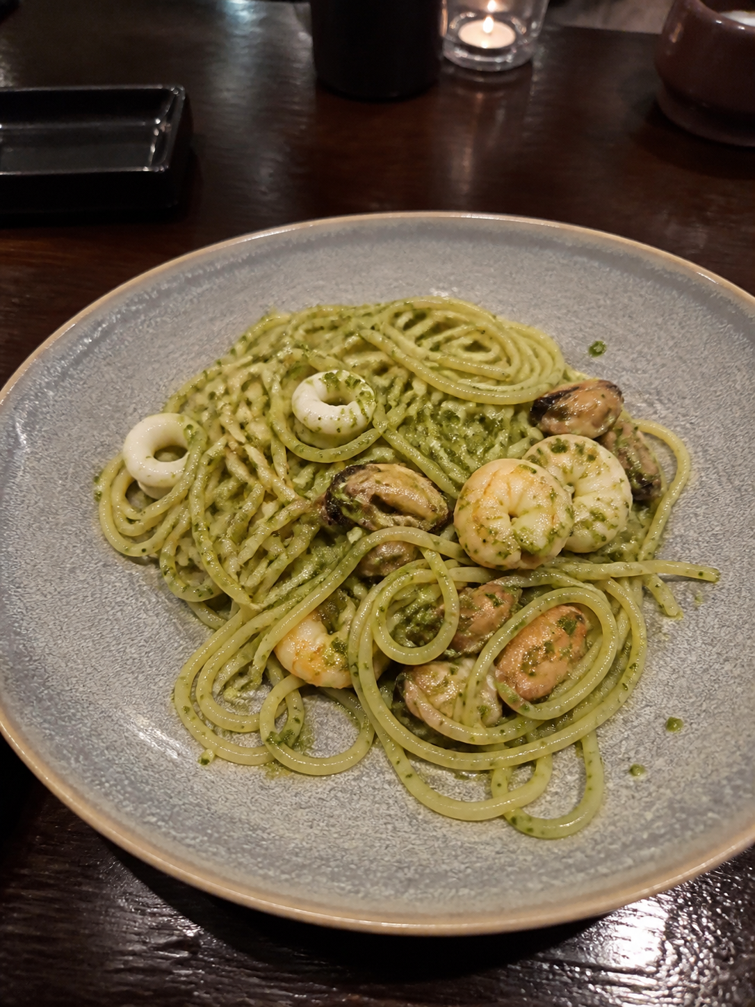 Pesto spaghetti with cooked prawns, squid and mussels