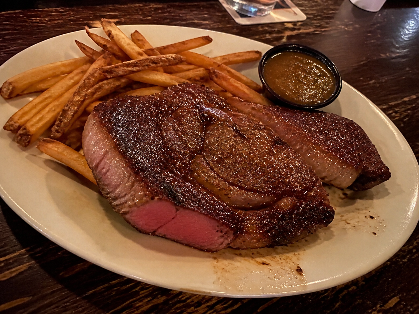 Grilled rib eye steak with fries and sauce