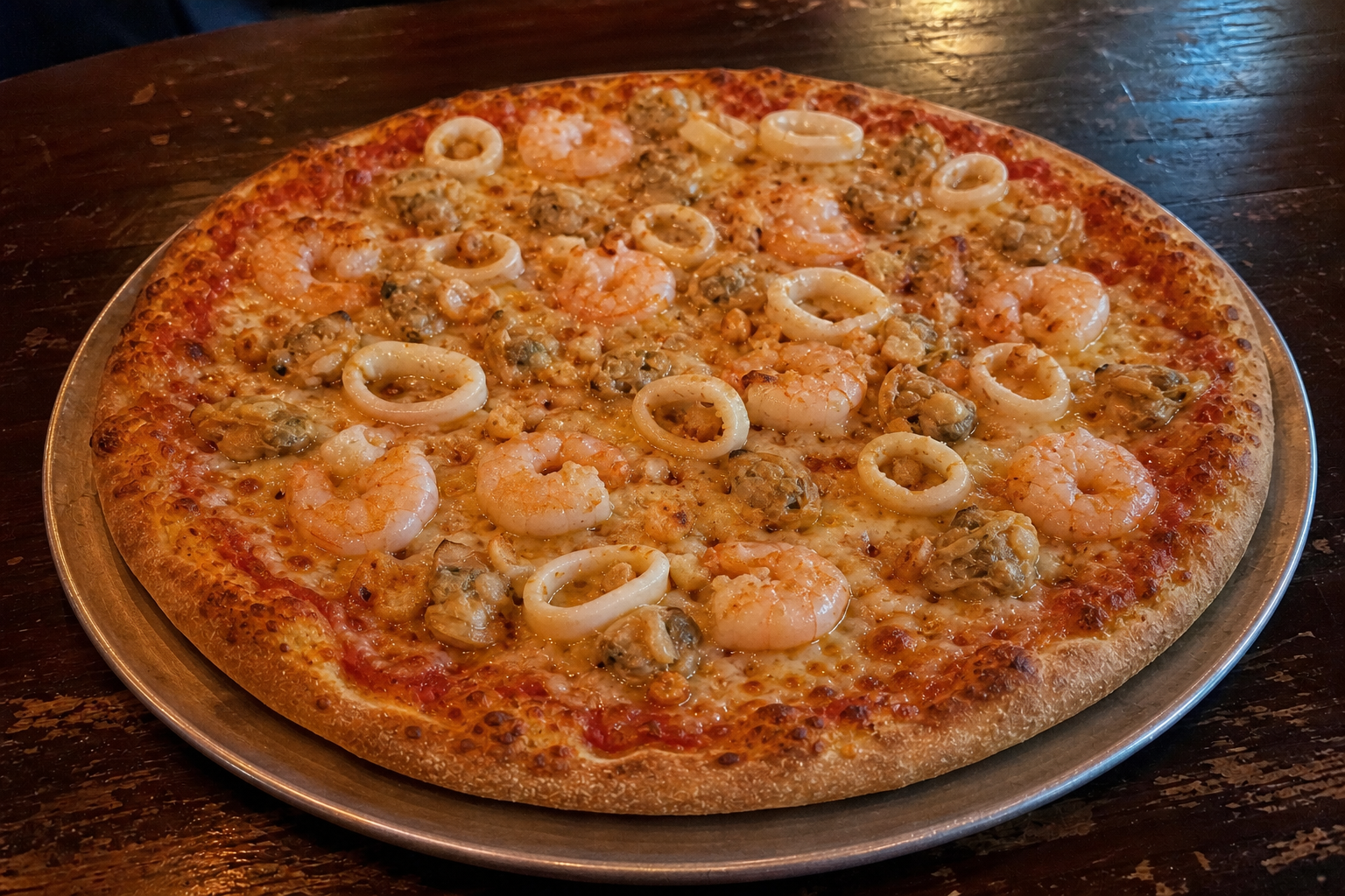 Hand-tossed seafood pizza with shrimp, clams, squid and garlic