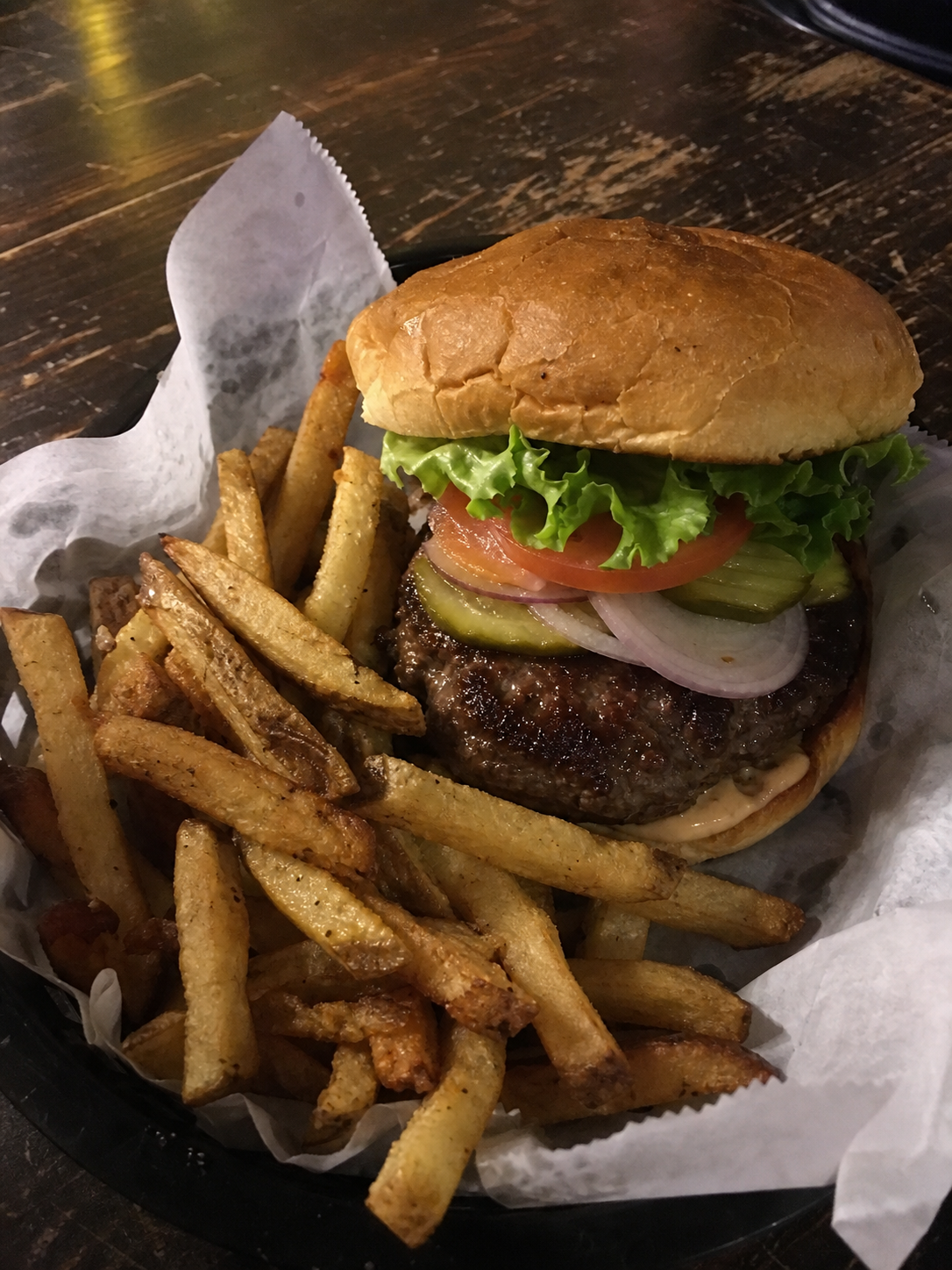 Signature beef burger with lettuce, tomato, onion, pickles and fries