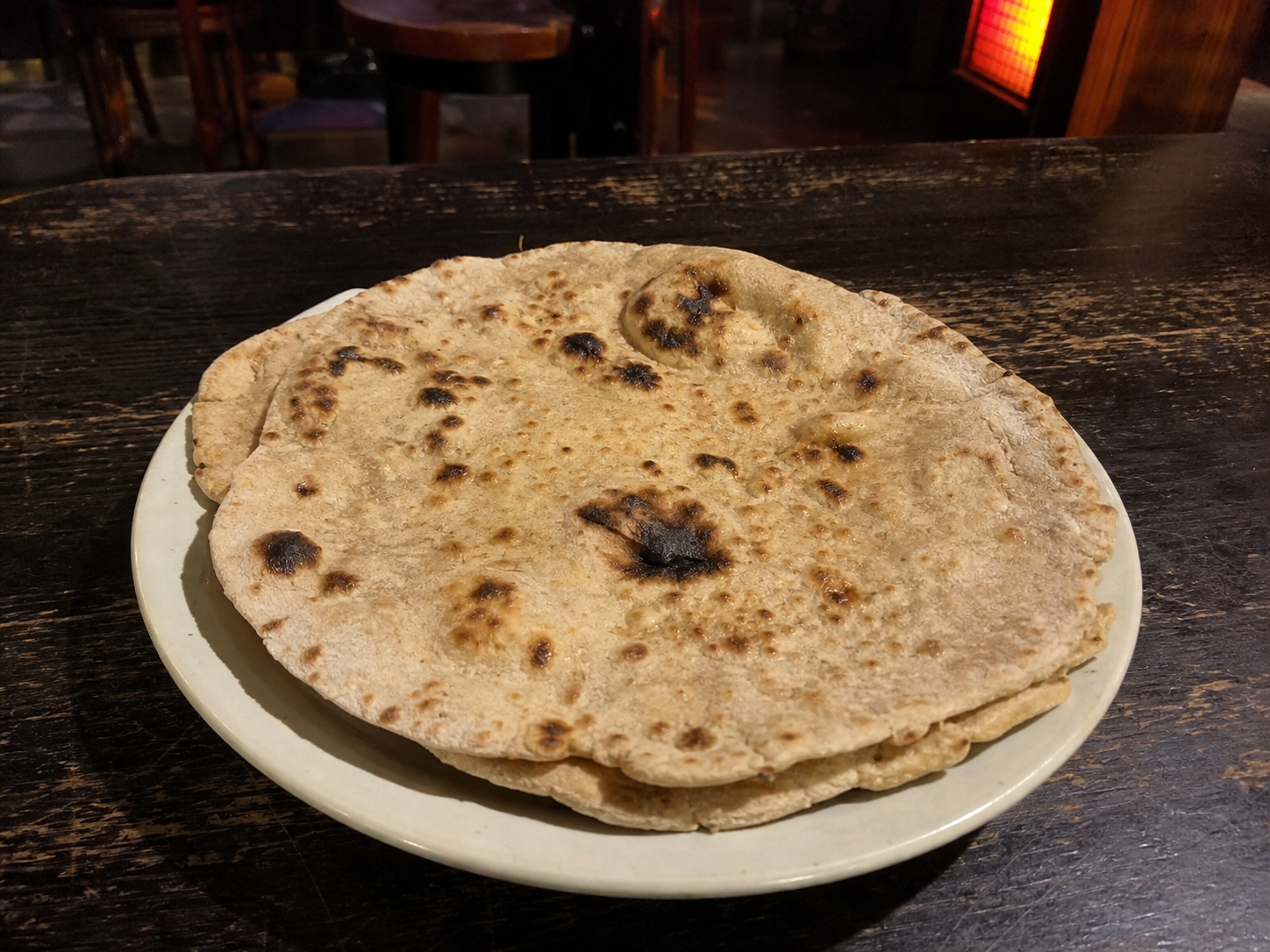 Stack of whole-wheat tandoori rotis with charred spots